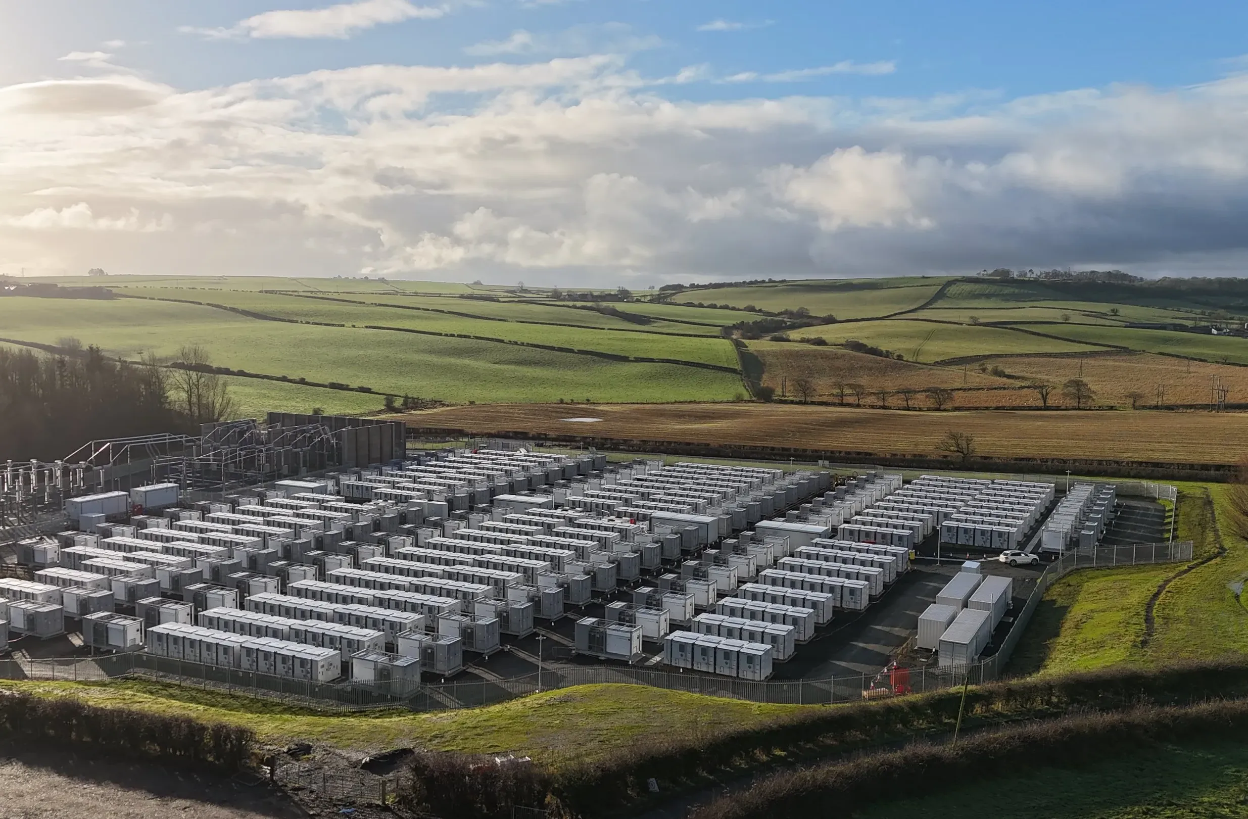 Aerial view of a battery energy storage site surrounded by farmland.